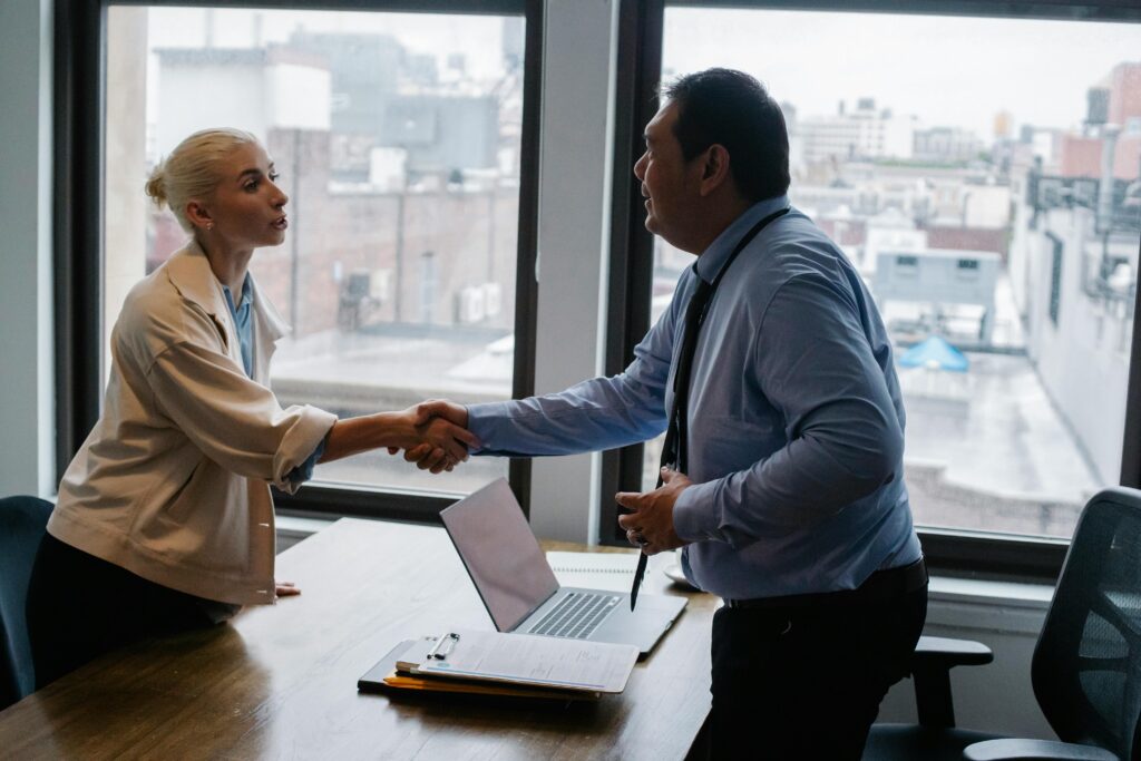 an employer and an employee shaking hands at the end of a successful stay interview