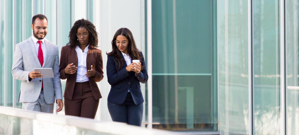 Three colleague walking towards a building